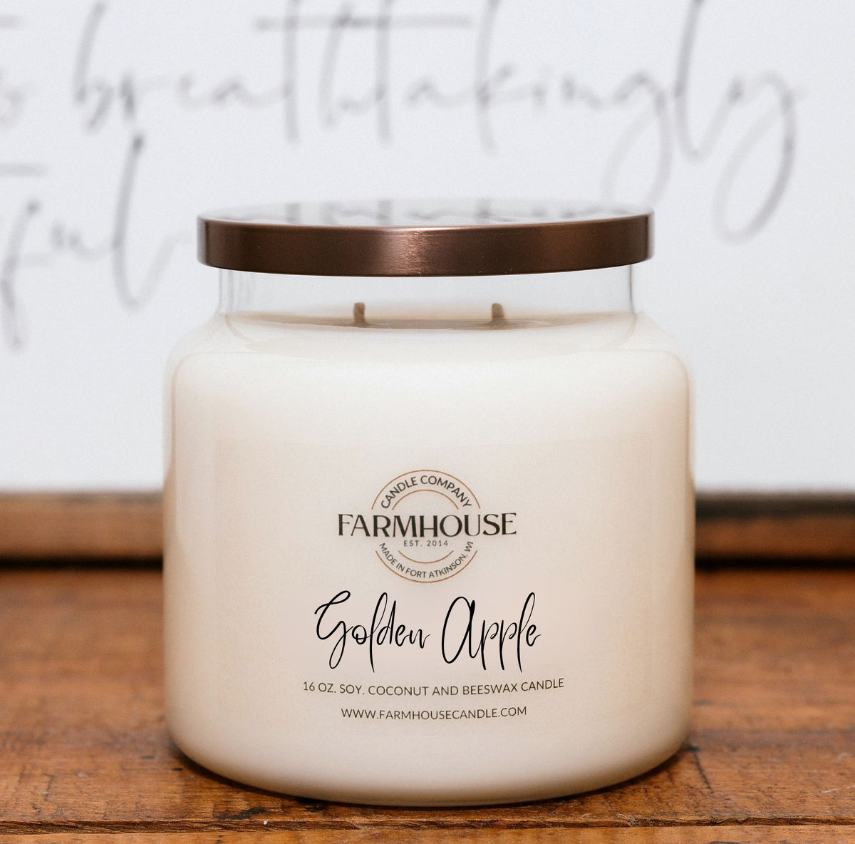 A Farmhouse Candle Company brand candle labeled 'Golden Apple' made with soy, coconut and beeswax in a glass jar with bronze metal lid.