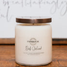 Farmhouse Candle Company candle labeled 'Dark Orchard' on a wooden surface with a blurred background.