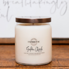 A Farmhouse Candle Company brand candle labeled 'Golden Apple' made with soy, coconut and beeswax in a glass jar with bronze metal lid.