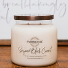 Farmhouse Candle Company jar candle labeled 'Sugared Black Currant' on a wooden surface.