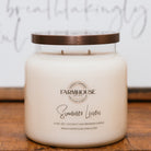 Farmhouse Candle Company jar candle  scent name Summer Linen with a bronze lid on a wooden surface.
