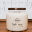 Farmhouse Candle Company Golden Papaya candle on a wooden surface with a white background