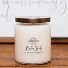 Farmhouse Candle Company 'Baked Apple' scented soy, coconut and beeswax candle in a clear glass jar with a bronze lid.