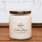 Farmhouse Candle Company 'Cranberry Prosecco' scented soy, coconut and beeswax candle in a clear glass jar with a bronze lid.